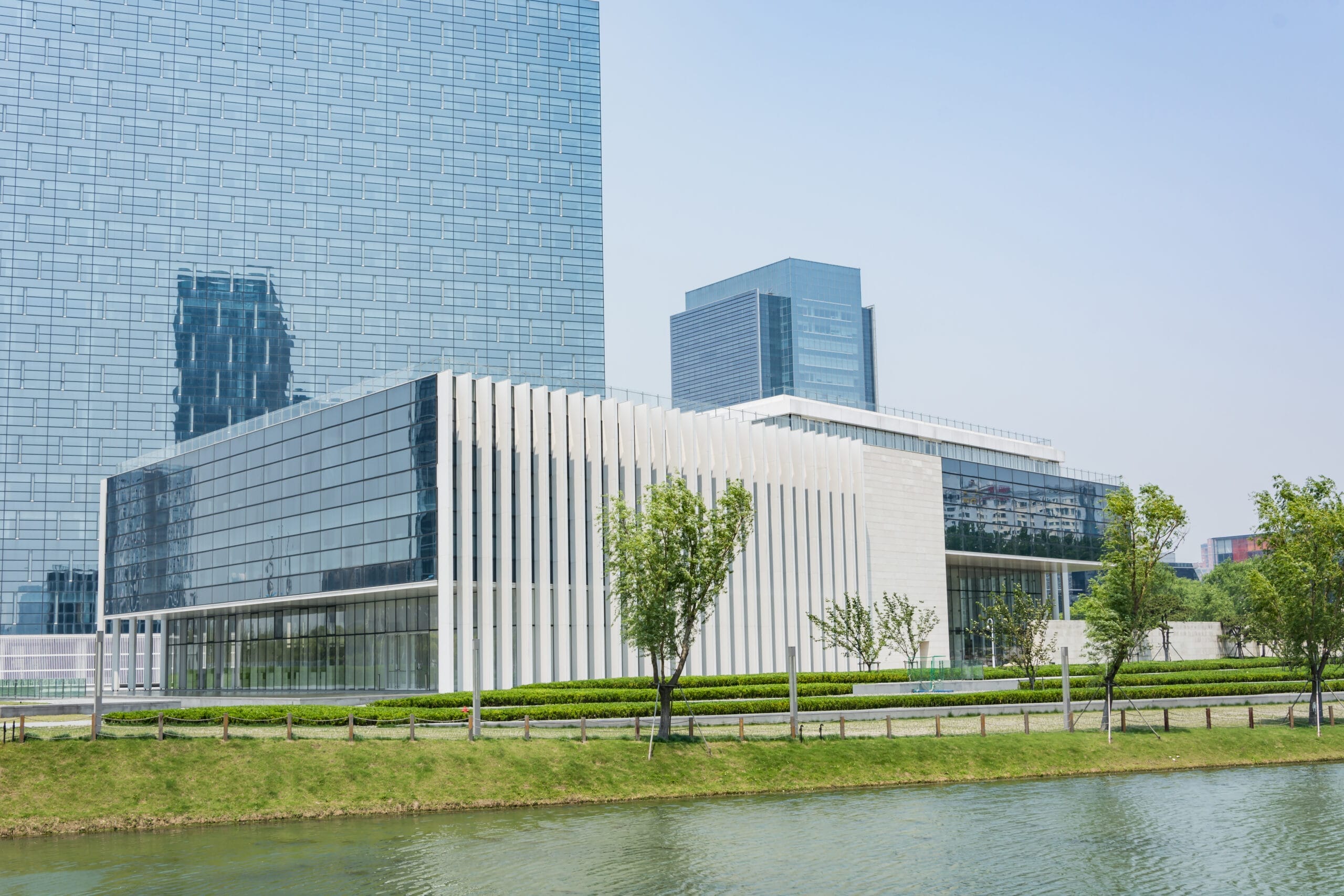 Modern glass and stone office building near a canal